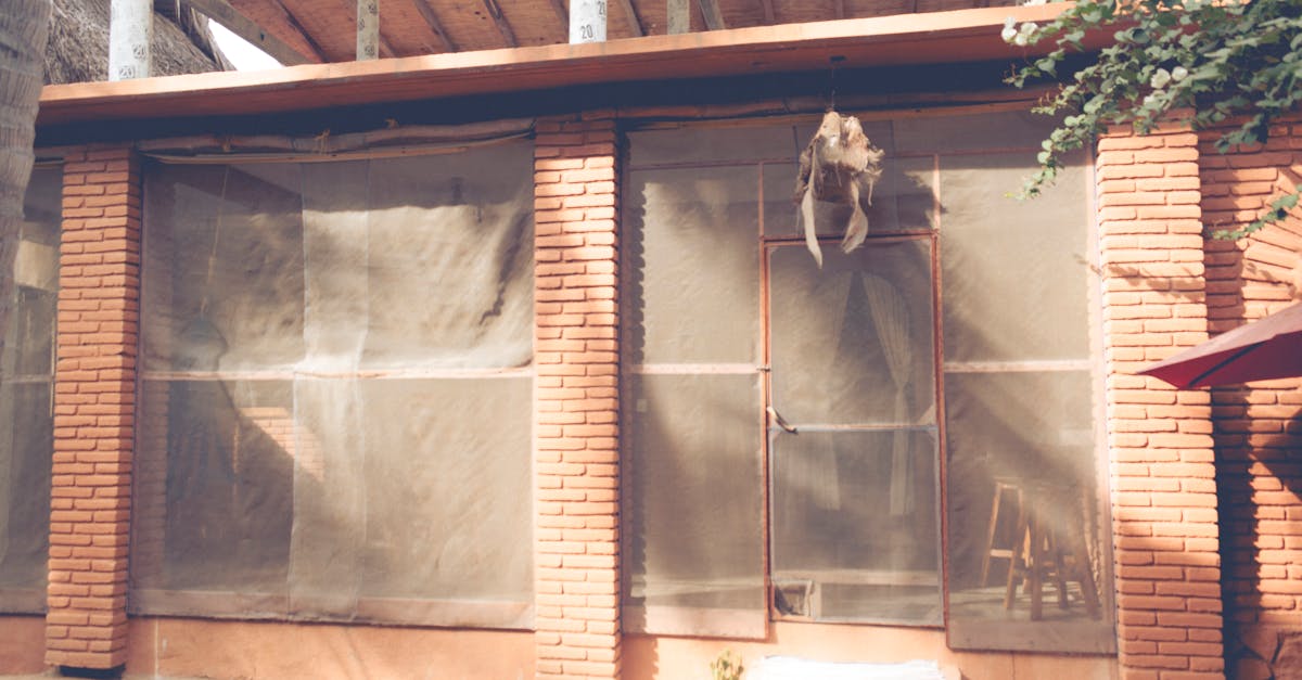 A rustic brick building with sheer curtains, wooden roof, and natural light.